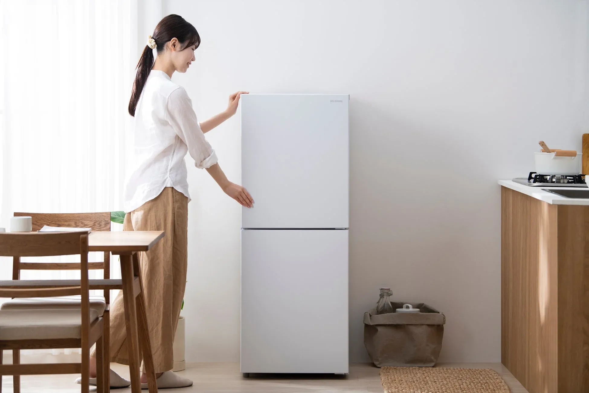 女性が冷蔵庫を開ける様子