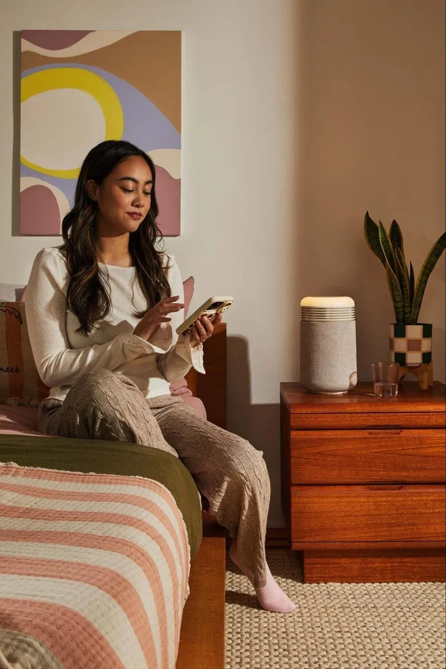 女性がベッドでスマートフォンを操作