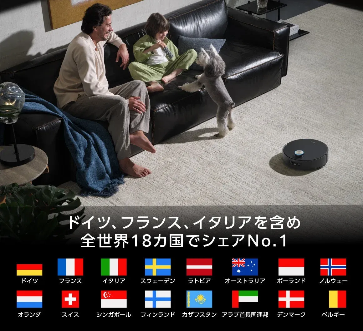 リビングでくつろぐ家族と犬のそばで、ロボット掃除機が稼働している様子
