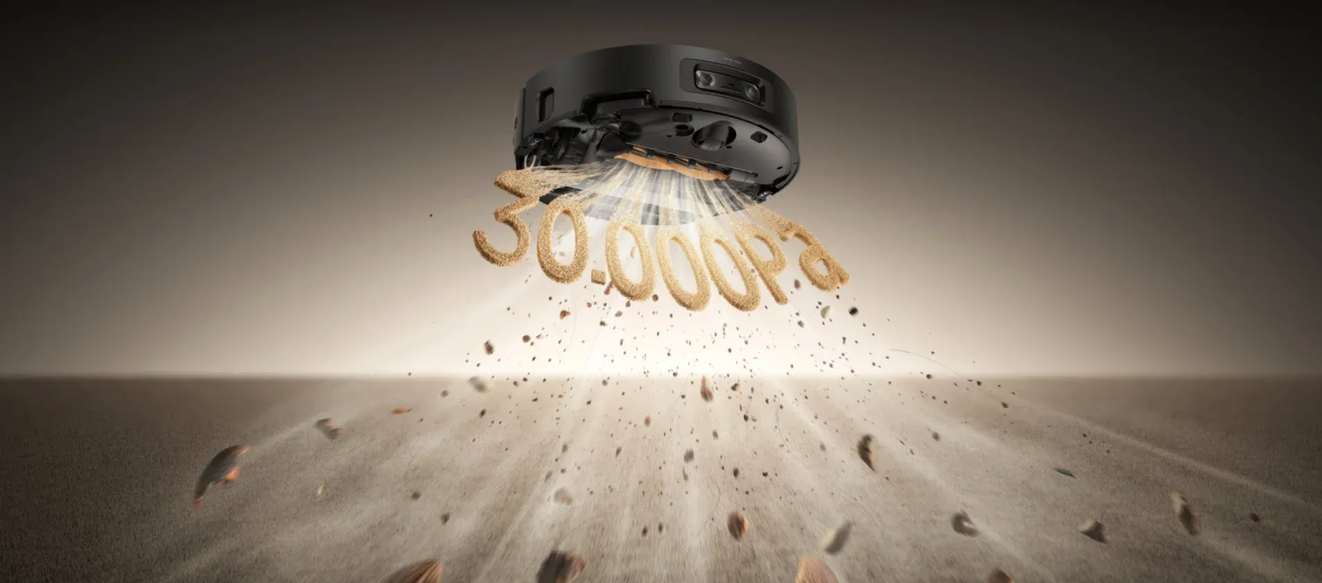 黒いロボット掃除機が強力な吸引力で砂やゴミを吸い上げている様子