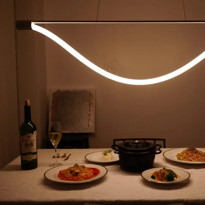 モダンな照明の下で、ワインと複数の料理が並べられた食卓の様子。