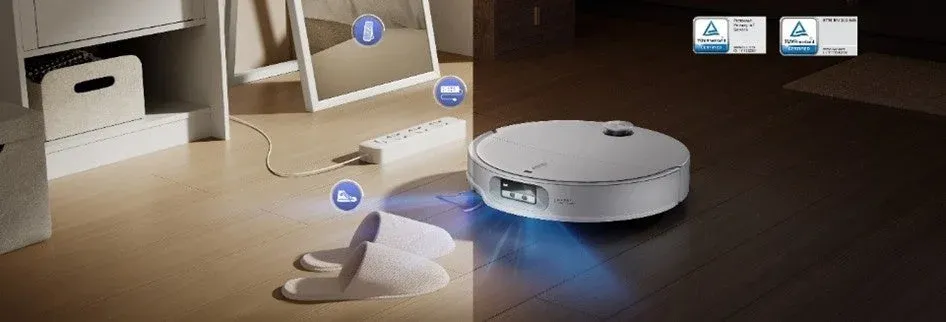 木製の床の上で稼働している白いロボット掃除機がスリッパや電源タップなどの障害物を避けている様子