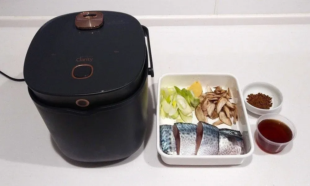 黒い調理家電と、サバの切り身などの食材