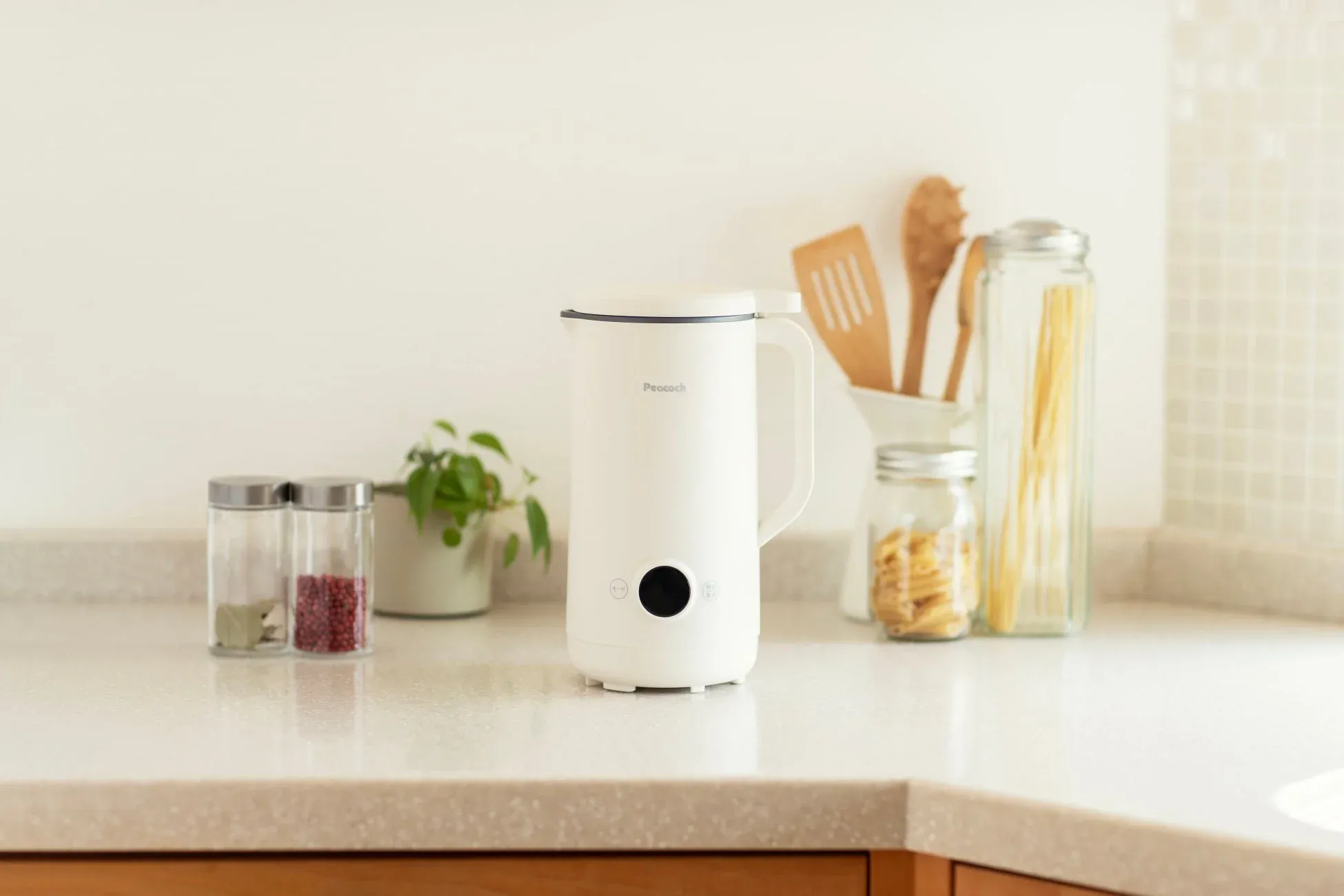 明るいキッチンカウンターに白い調理家電が置かれた様子