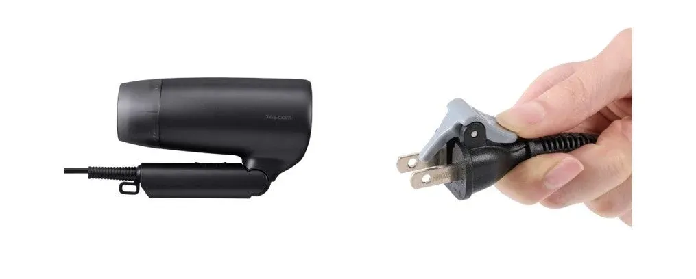 黒いヘアドライヤーと電源プラグを握る手