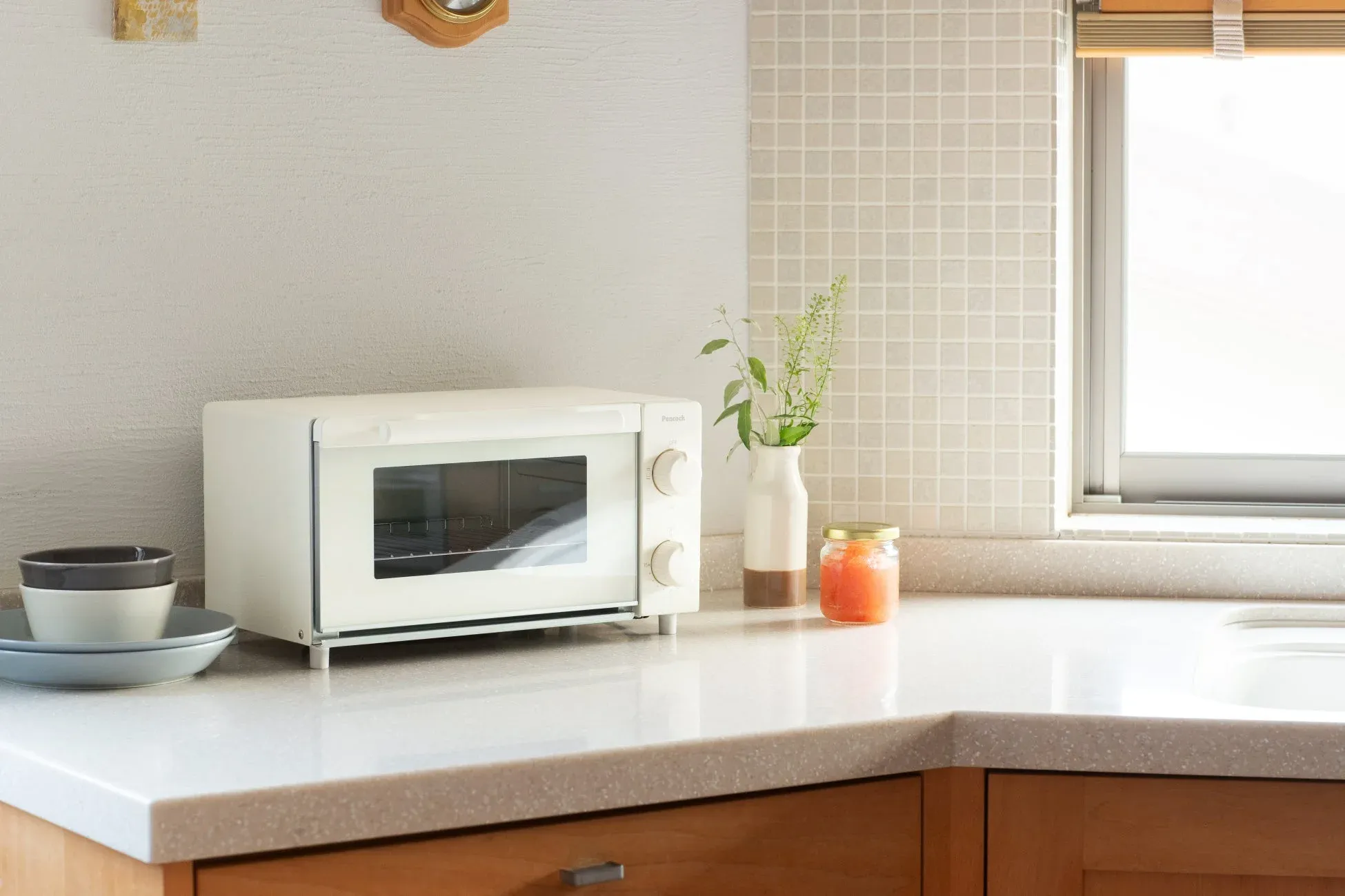 明るい光が差し込むキッチンカウンターに白いトースター