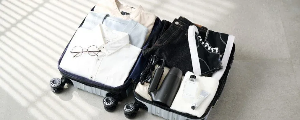 開いたスーツケースの中にきれいに収納された衣類や日用品