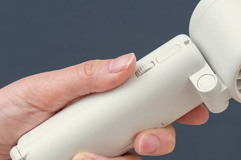 白いポータブルデバイスを握る手のクローズアップ