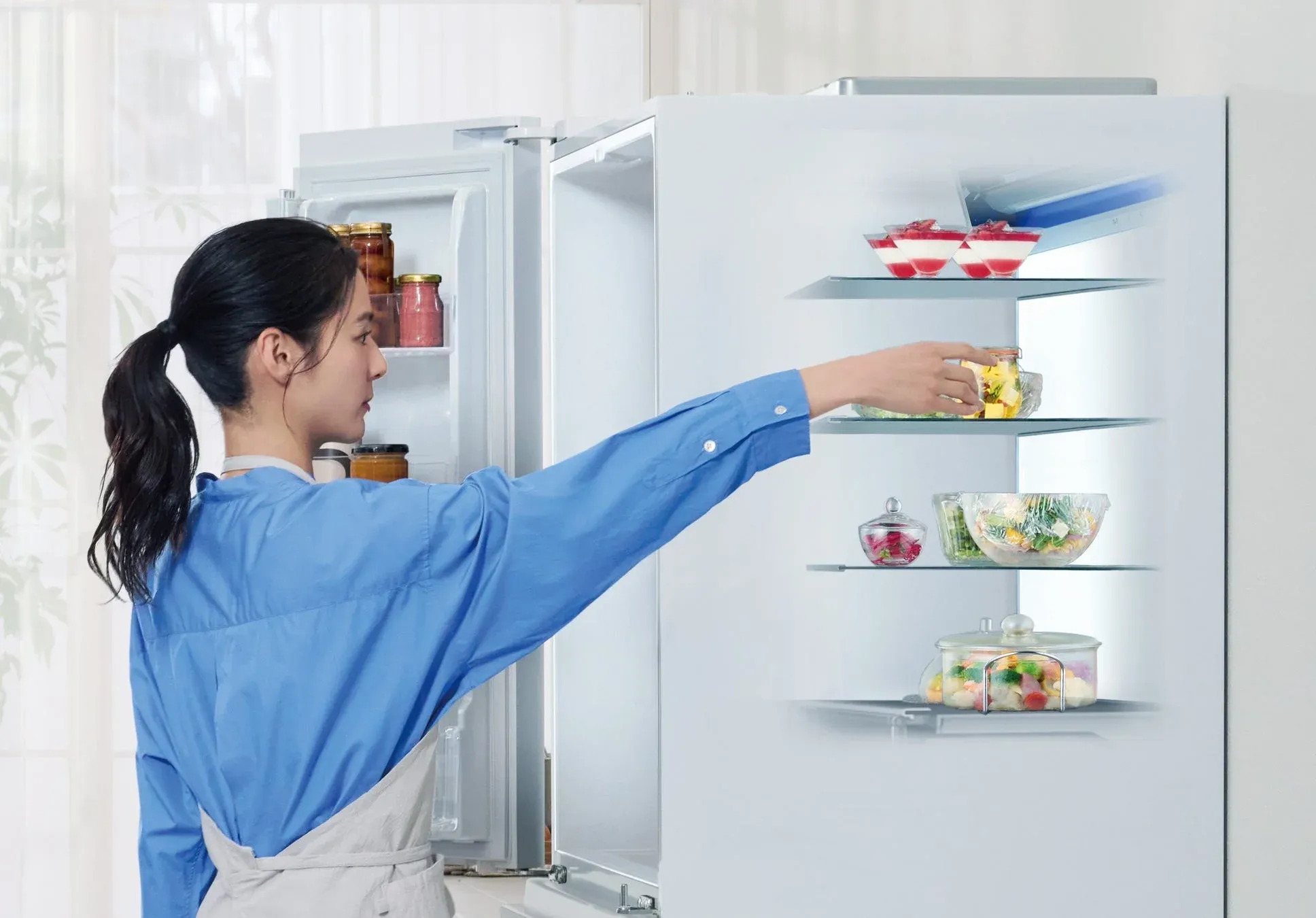 冷蔵庫から食べ物を取り出す女性