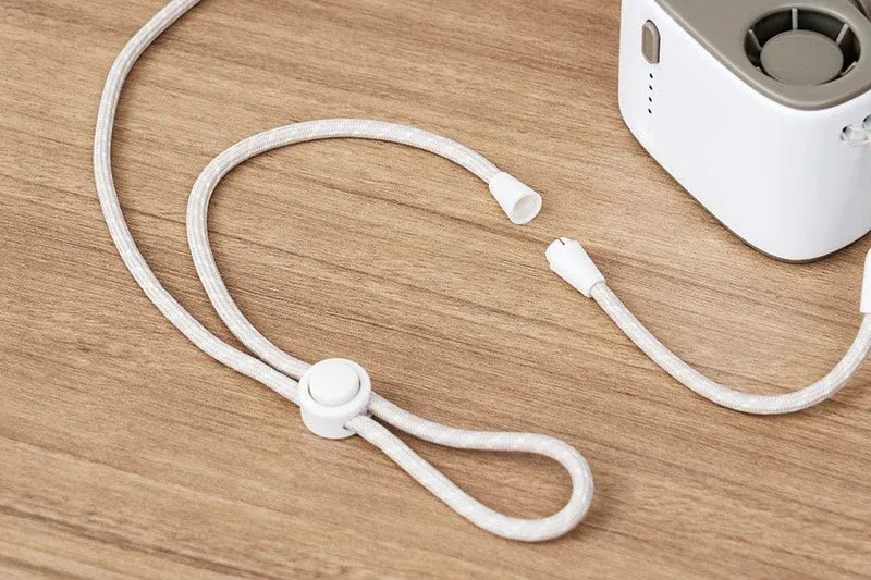 白い携帯デバイスと、そのデバイスに取り付けるための白い調節可能なストラップが木目のテーブルの上に置かれている様子