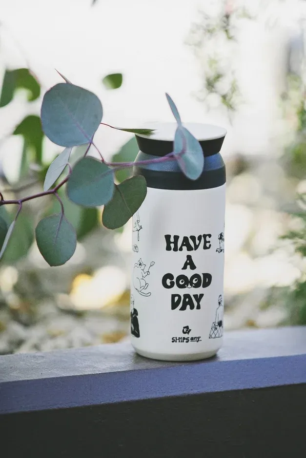 「HAVE A GOOD DAY」とイラストが描かれた白いサーモボトル