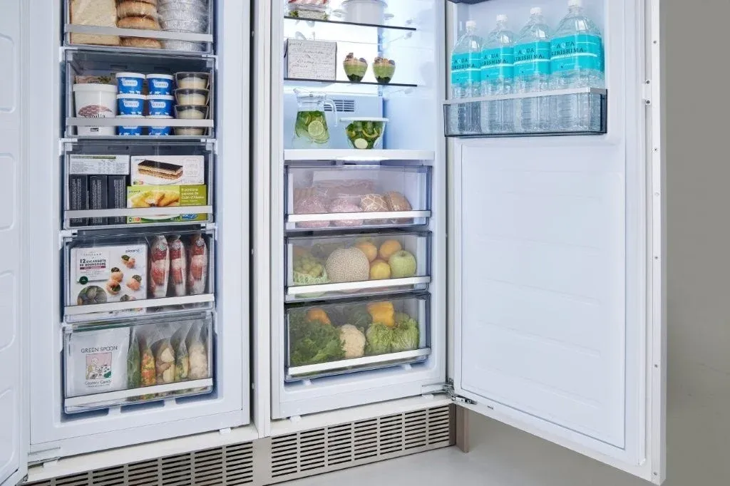 扉が開いた状態のサイドバイサイド冷蔵庫で、冷凍庫と冷蔵庫の内部が写っています