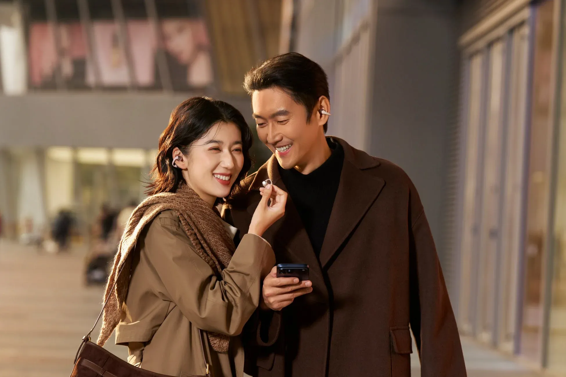 ワイヤレスイヤホンを身につけた笑顔のカップル