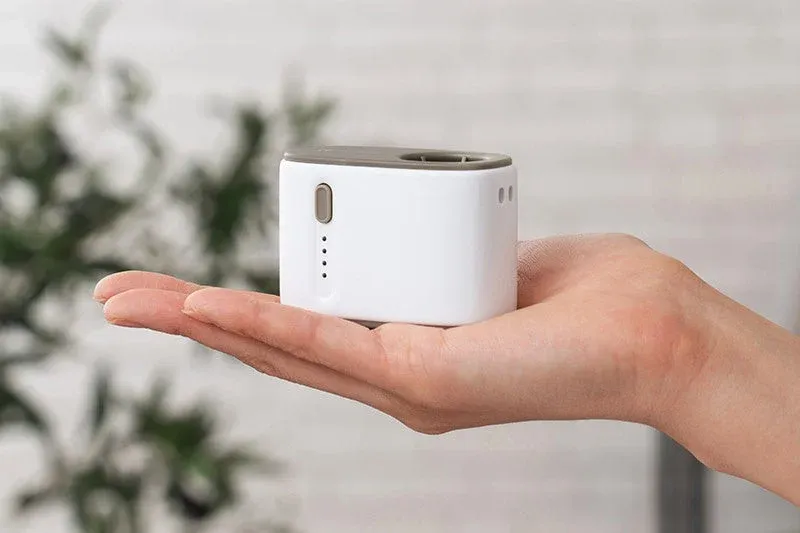 白とグレーを基調とした小型の電子デバイスが手のひらに乗せられており、そのコンパクトなサイズ感が強調されています